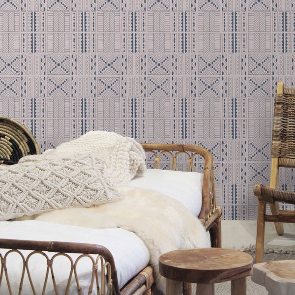 Ein Schlafzimmer mit einem Bett und einer Wandtapete mit geometrischem Muster