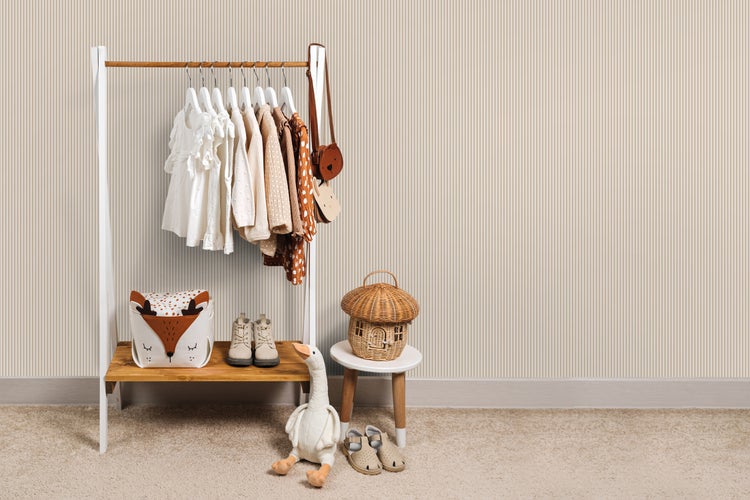 Kinderzimmer mit Kleiderständer, Kleidung, Dekoration und Spielzeug.