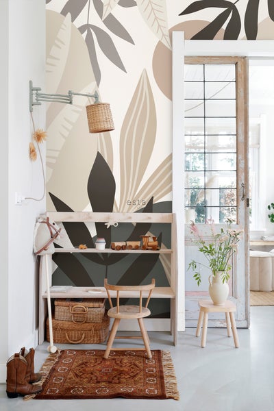Kinderzimmer mit einem Regal voller Spielzeug, einem Kinderstuhl und einer Tapete mit Pflanzenmotiven
