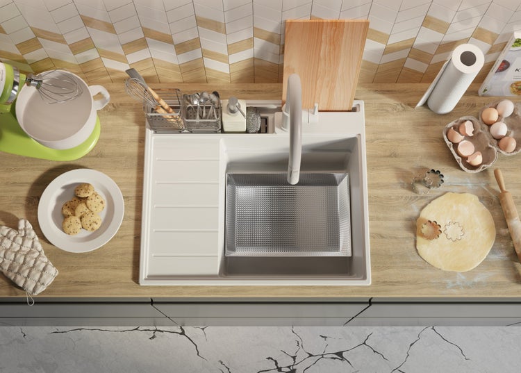 Küchenszene mit Spüle, Armatur und Backutensilien auf einer Arbeitsplatte.