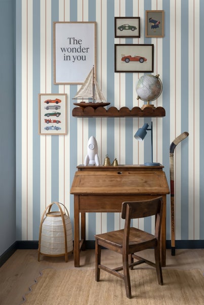 Gestreifte Vliestapete in Blau und Weiß mit schmalen orangefarbenen Streifen in einem Kinderzimmer mit Holzschreibtisch und Holzstuhl.