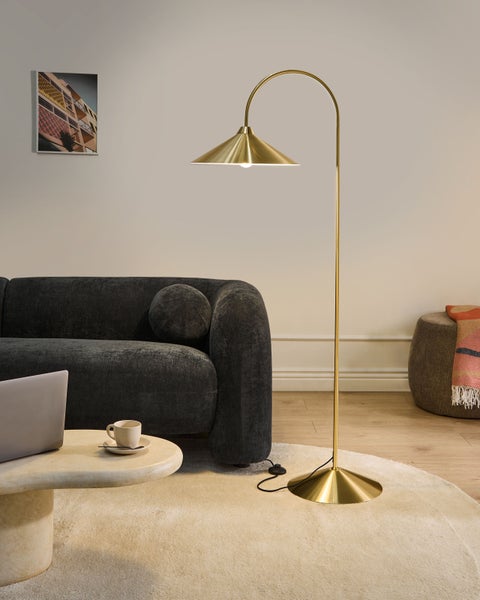 Wohnzimmer mit Stehlampe, Sofa, Tisch und Teppich für eine gemütliche Atmosphäre