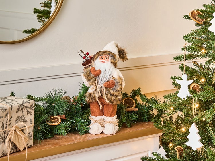 Dekorativer Weihnachtsmann mit Geschenk, Girlande und Weihnachtsbaum