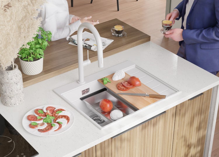 Küchenszene mit Spüle, Armatur, Schneidebrett, Mozzarella, Tomaten und Basilikum