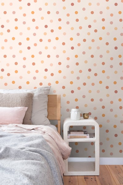 Schlafzimmer mit Bett, Nachttisch und Tapete mit Punktmuster