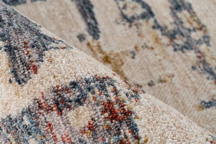 Nahaufnahme eines Teppichs mit Vintage-Muster und dichter Florstruktur in Beige, Blau und Orange.