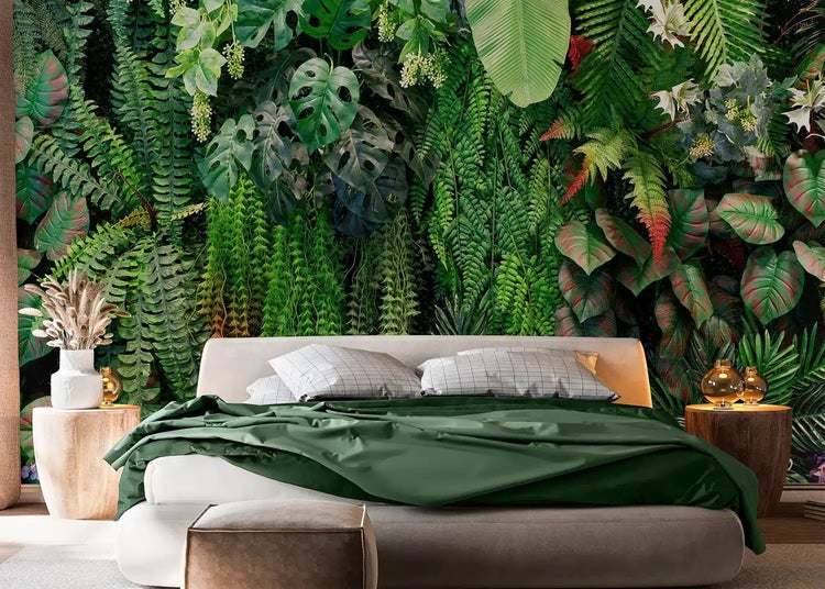 Fototapete mit Dschungelmotiv aus Farnen und Monstera in einem Schlafzimmer mit grünem Bett.
