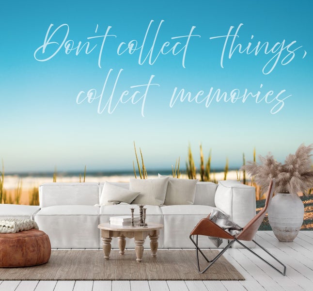 Dekoratives Wohnzimmer mit Sofa, Sessel und Wandbild mit inspirierendem Zitat