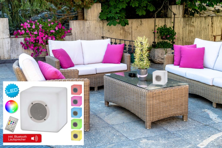 Terrassenszene mit Rattansofas, Tisch und LED-Lautsprecherwürfel