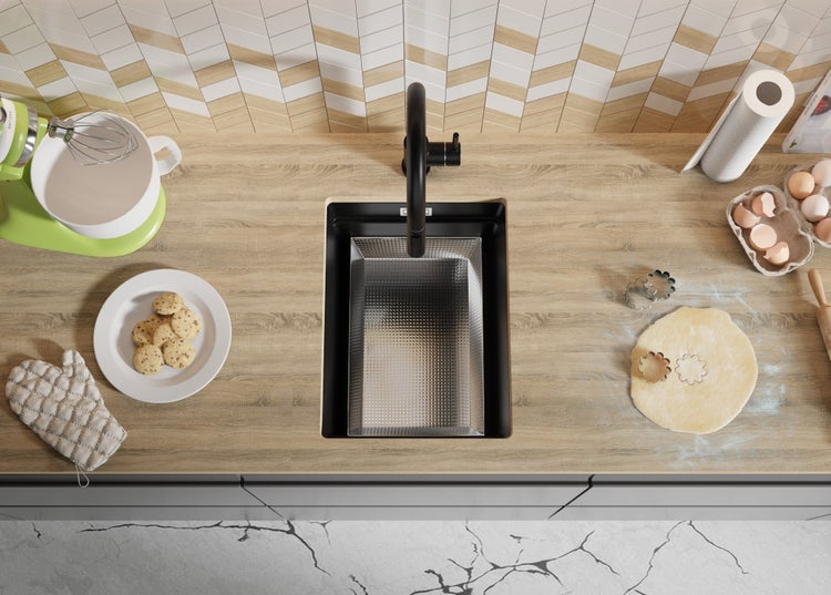 Küchenszene mit Spüle, Armatur, Küchenmaschine und Backzutaten auf einer Arbeitsplatte