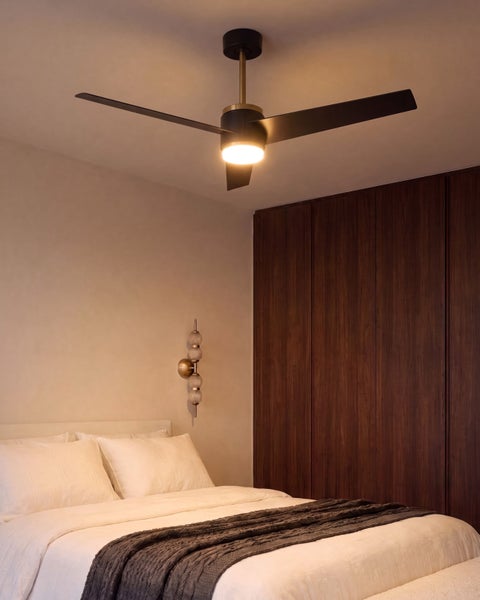 Moderner Deckenventilator mit integrierter LED Beleuchtung in einem eleganten Schlafzimmer mit dunklem Holzschrank und gemütlichem Bett.