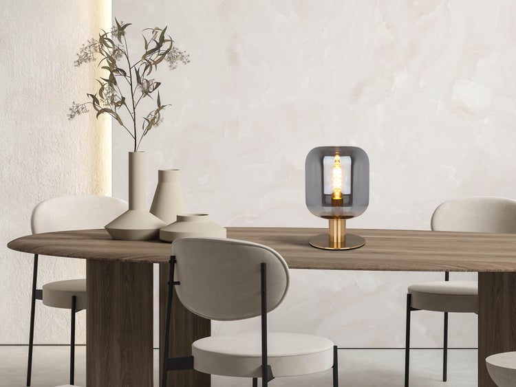 Esstisch mit Stühlen, Vasen und einer Tischleuchte.