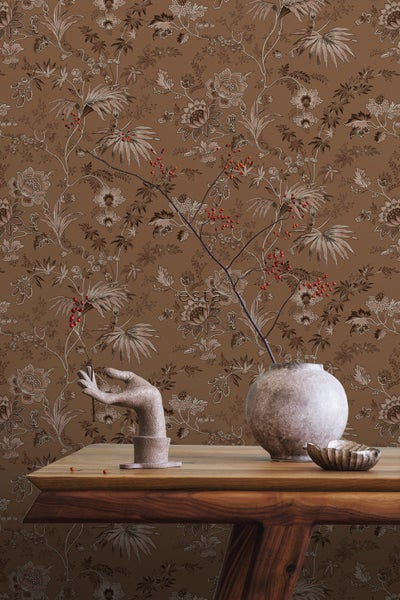 Dekoratives Wohnzimmer mit floraler Tapete, Holztisch und dekorativen Objekten