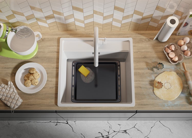 Küchenszene mit Spüle, Backblech, Teig und Küchenutensilien von oben