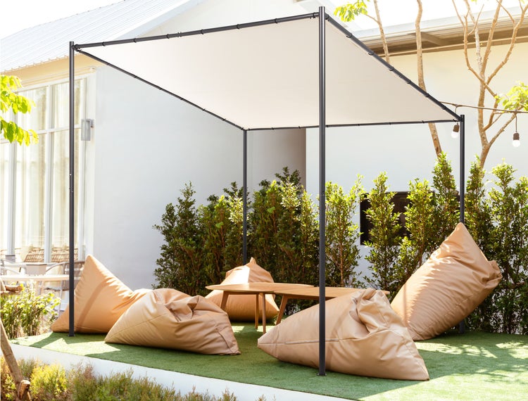 Schwarzes Spanngummi mit Kunststoffkugel zur Befestigung eines hellen Stoffes an einer schwarzen Metallstange.