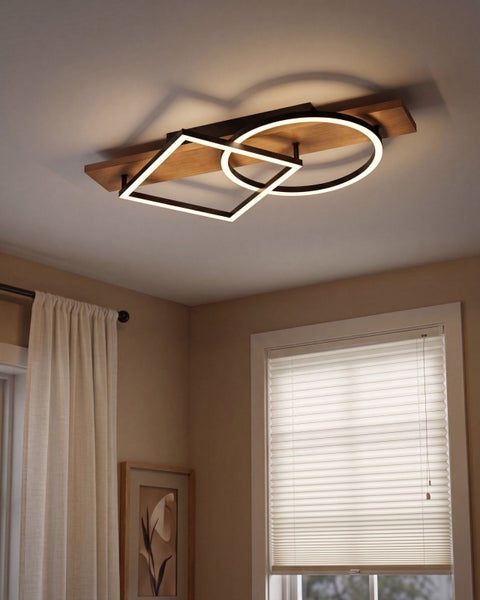 Moderne LED Deckenleuchte mit quadratischen und runden Elementen auf einer Holzplatte in einem gemütlich eingerichteten Raum.