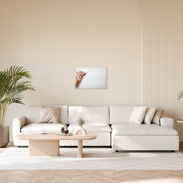 Wohnzimmer mit Sofa, Tisch und Wandbild eines Highland Rindes