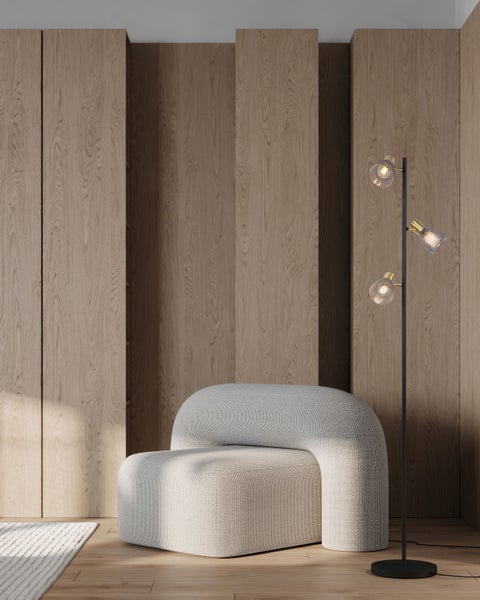 Szene mit Sessel und Stehlampe vor einer Holzwand