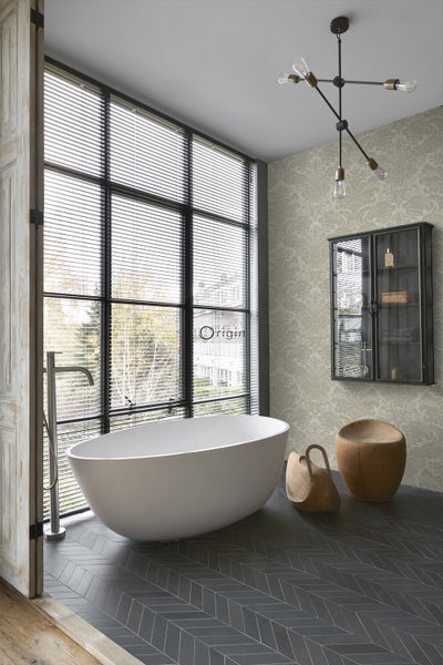 Modernes Badezimmer mit freistehender Badewanne, großem Fenster mit Jalousien, gemusterter Tapete und dunklem Fliesenboden im Fischgrätmuster.