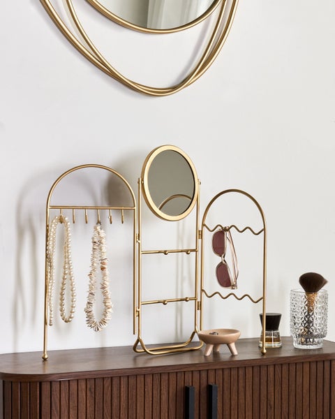 Goldfarbener Schmuckständer mit Spiegel und Accessoires auf einem Holzschrank