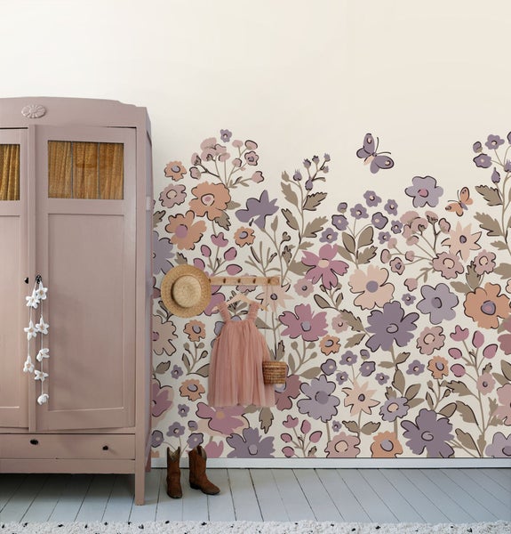 Einrichtung eines Kinderzimmers mit Kleiderschrank und Blumendekor an der Wand.