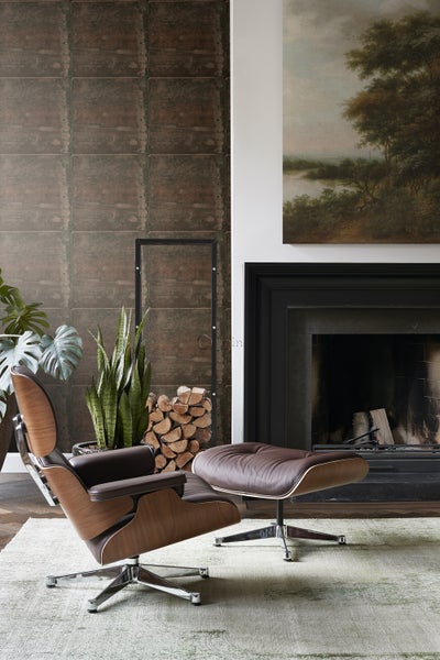 Wohnzimmer mit Sessel, Fußhocker, Kamin und Dekoration