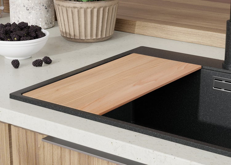 Küchenspüle mit Schneidebrett und Brombeeren in einer Schale