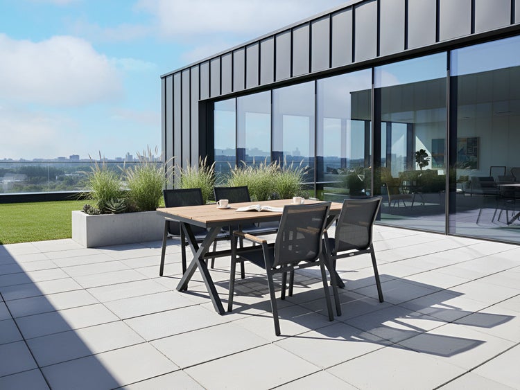 Terrasse mit Gartentisch und Stühlen vor einem modernen Gebäude.