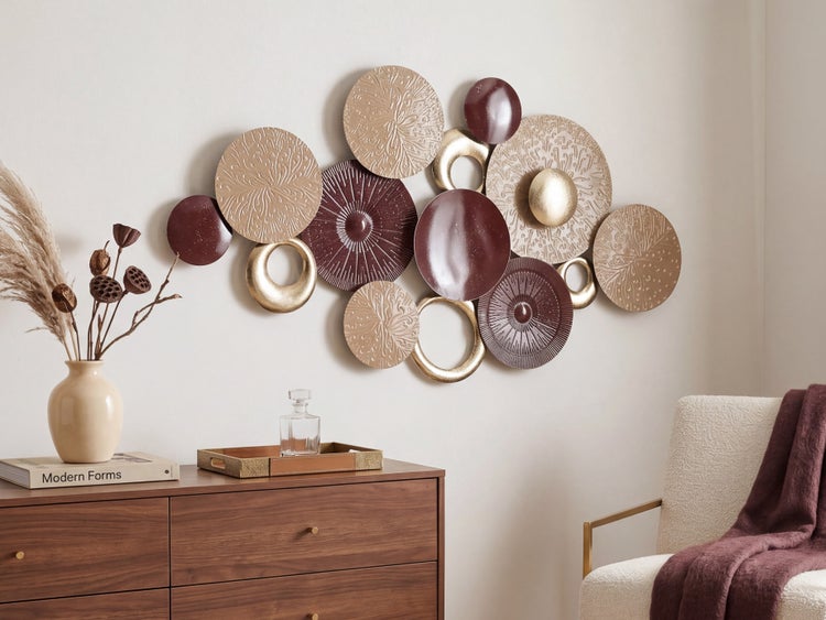 Moderne Wanddekoration aus Metall mit strukturierten Scheiben und Ringen über einer Kommode aus Holz in einem hellen, organisierten Wohnzimmer.