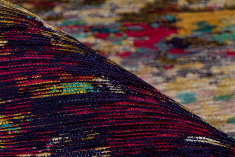 Nahaufnahme eines bunt gemusterten Teppichs mit strukturierter, gewebter Oberfläche und abstraktem Design.