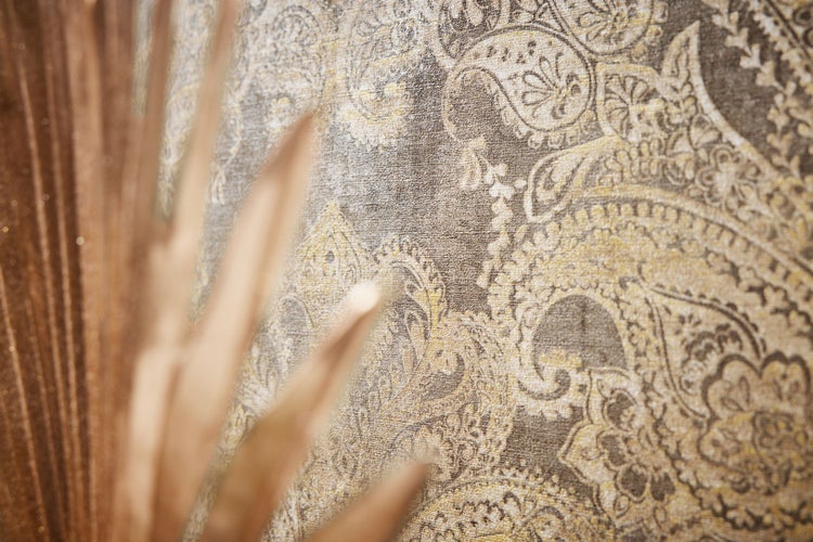 Dekoratives Interieur mit gemusterter Tapete, Sessel und Accessoires für ein stilvolles Wohnambiente.