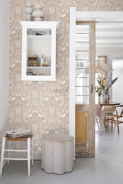 Dekoratives Zimmer mit gemusterter Tapete, Hocker und Sitzgelegenheit