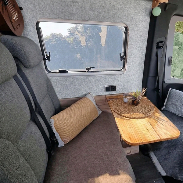 Innenraum eines Wohnmobils mit Sitzgelegenheit, Tisch und Fenster