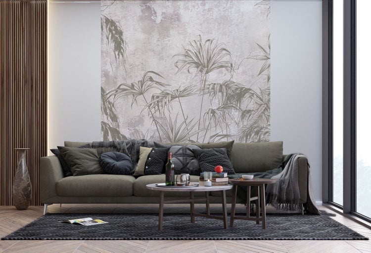 Wohnzimmer mit Sofa, Couchtischen, Teppich und dekorativer Wandtapete mit Pflanzenmotiven