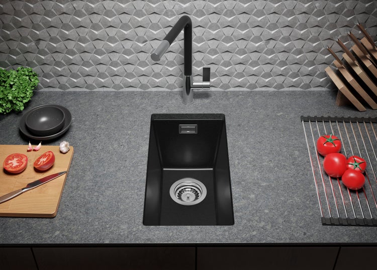 Küchenspüle mit Armatur auf einer Arbeitsplatte, ergänzt durch Schneidebrett und Abtropfgestell