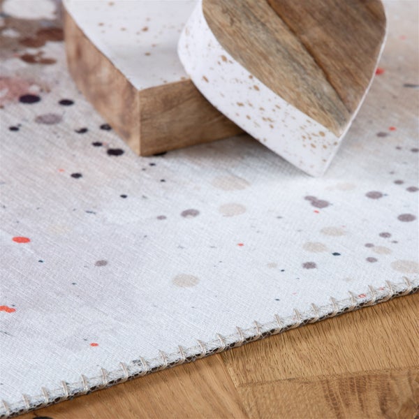 Läufer mit Farbspritzer-Muster und Kettelnaht auf Parkettboden, dekoriert mit zwei dekorativen Herzen aus Holz und Stein-Optik.