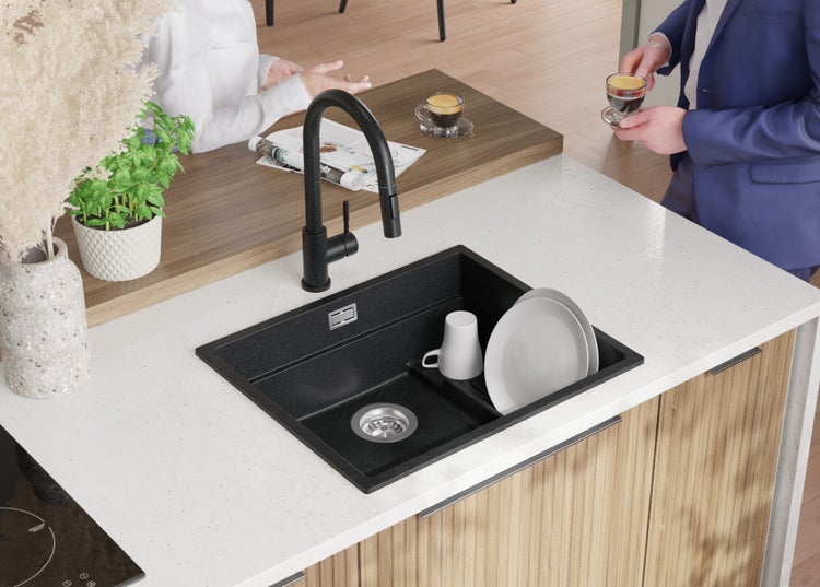 Küchenspüle mit Wasserhahn und Geschirr auf einer Küchentheke