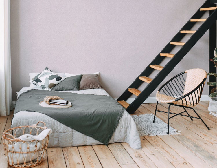 Schlafzimmer mit Holzbett, Nachttisch und Zimmerpflanze