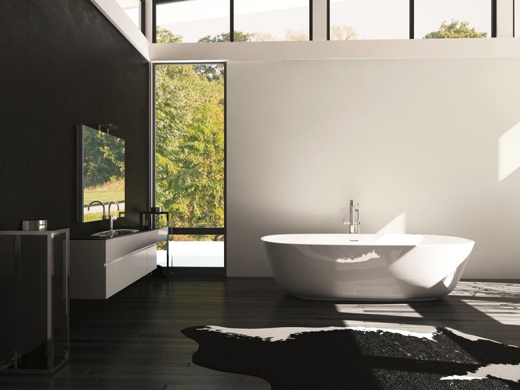 Helles Badezimmer mit Badewanne, Waschtisch und großem Fenster mit Blick auf die Natur