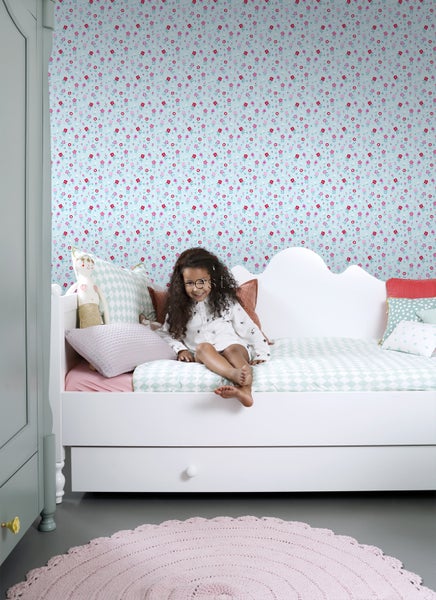 Mädchenzimmer mit gemusterter Tapete, Bett und Teppich