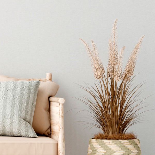 Dekorative Szene mit Bank, Kissen und Ziergras im Topf