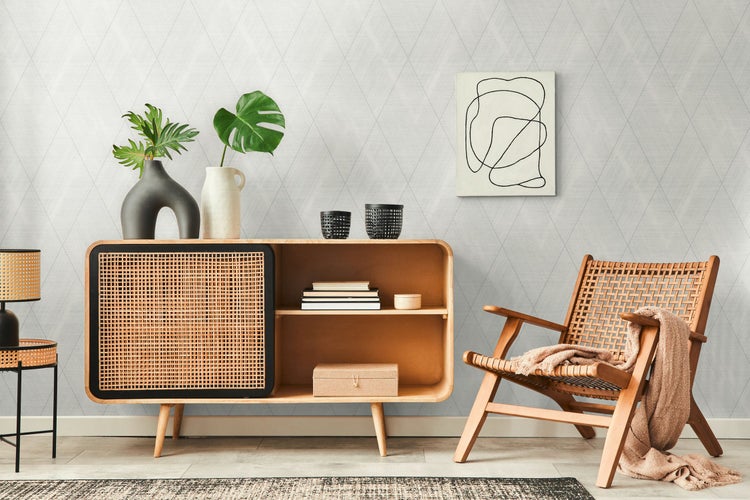 Wohnszene mit Stuhl, Decke, Lampe, Kaktus und geometrischer Tapete