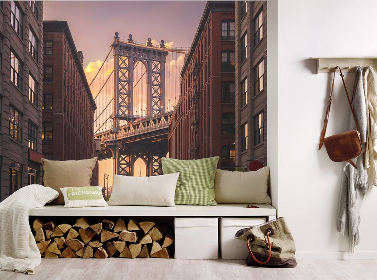 Fototapete mit der Manhattan Bridge in New York zwischen Backsteingebäuden in einem hellen, modern eingerichteten Raum mit einer Sitzbank.