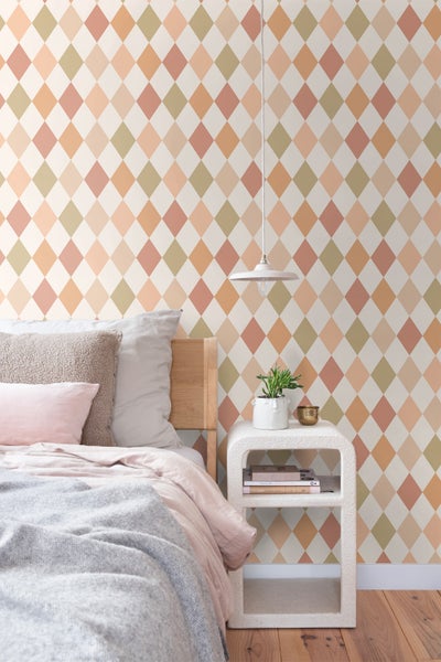 Schlafzimmer mit Bett, Nachttisch und Rautenmuster-Tapete