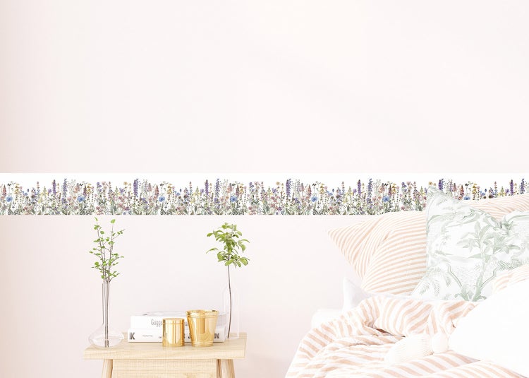 Tapetenbordüre mit Wildblumen-Motiv an einer Wand in einem modern eingerichteten Raum mit Sessel und Beistelltisch.