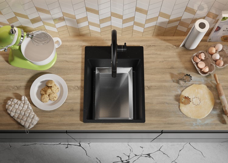 Küchenszene mit Spüle, Armatur, Geschirr, Zutaten und Küchenutensilien auf einer Arbeitsplatte.