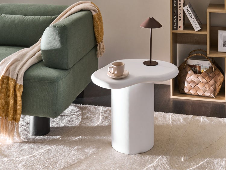 Wohnzimmer-Szene mit Sofa, Beistelltisch, Lampe und Dekorationen im Regal