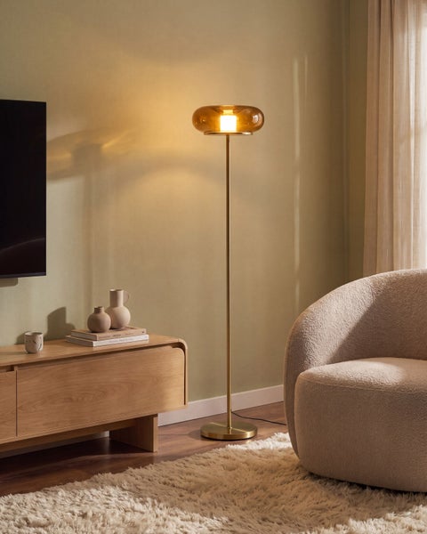 Moderne Stehleuchte mit rundem Glasschirm und schlankem Metallständer in einem Wohnzimmer