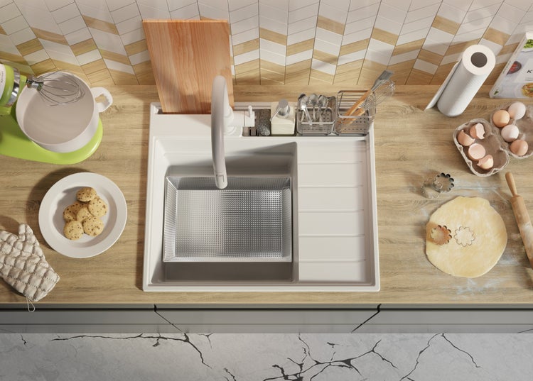 Küchenszene mit Spüle, Armatur, Geschirr, Lebensmitteln und Küchenutensilien auf einer Arbeitsplatte