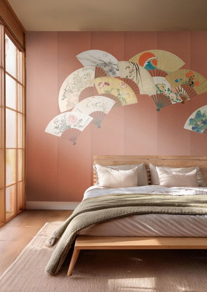 Schlafzimmer mit Doppelbett, hölzernem Bettgestell und Wandtapete mit Fächermotiven